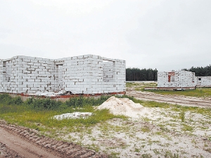 В новом дачном поселке под Быковней пока только коробки будущих домов и песок. На него обещают насыпать слой чернозема в 30 сантиметров. Фото Антона Лущика