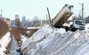 Коммунальщики сбрасывают снег в реку Лыбедь. Фото УНН.