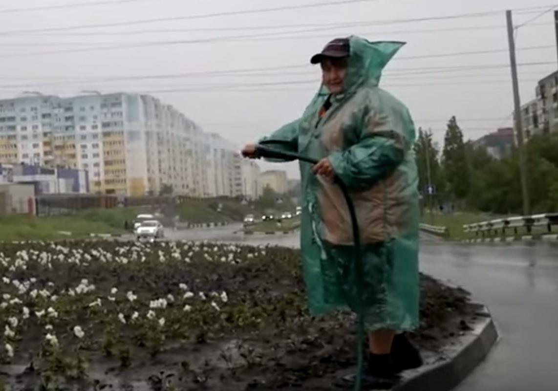 Новость - События - Приказы не обсуждаются: на Троещине коммунальщики поливают клумбы под проливным дождем
