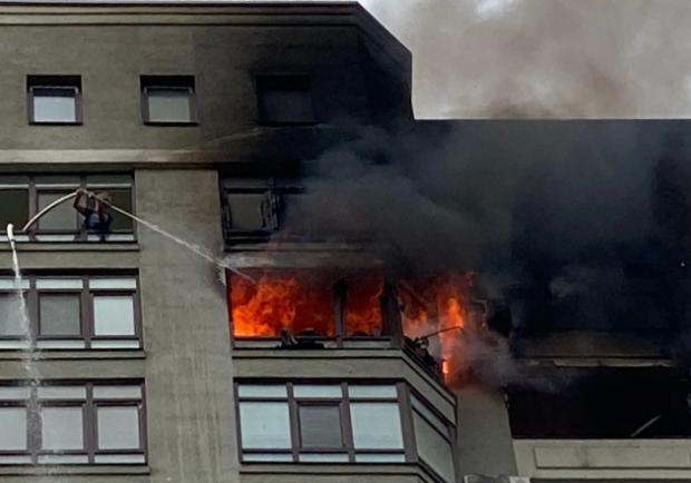 Горит многоэтажка: хозяйка квартиры чтобы спастись от огня вылезла на кондиционер. Фото: ГСЧС
