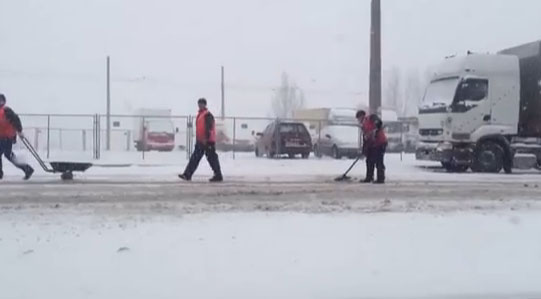 В Киеве дороги ремонтируют даже во время снегопада. Фото: кадр из видео. 