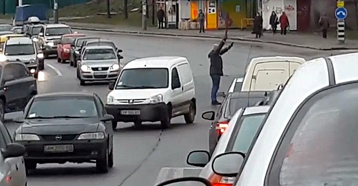Мужчина руководил сотнями автомобилей с помощью зонтика. Скриншот видео.