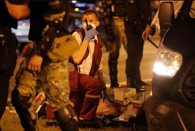 Врач оказывает помощь пострадавшему в акции протеста. Фото: meduza