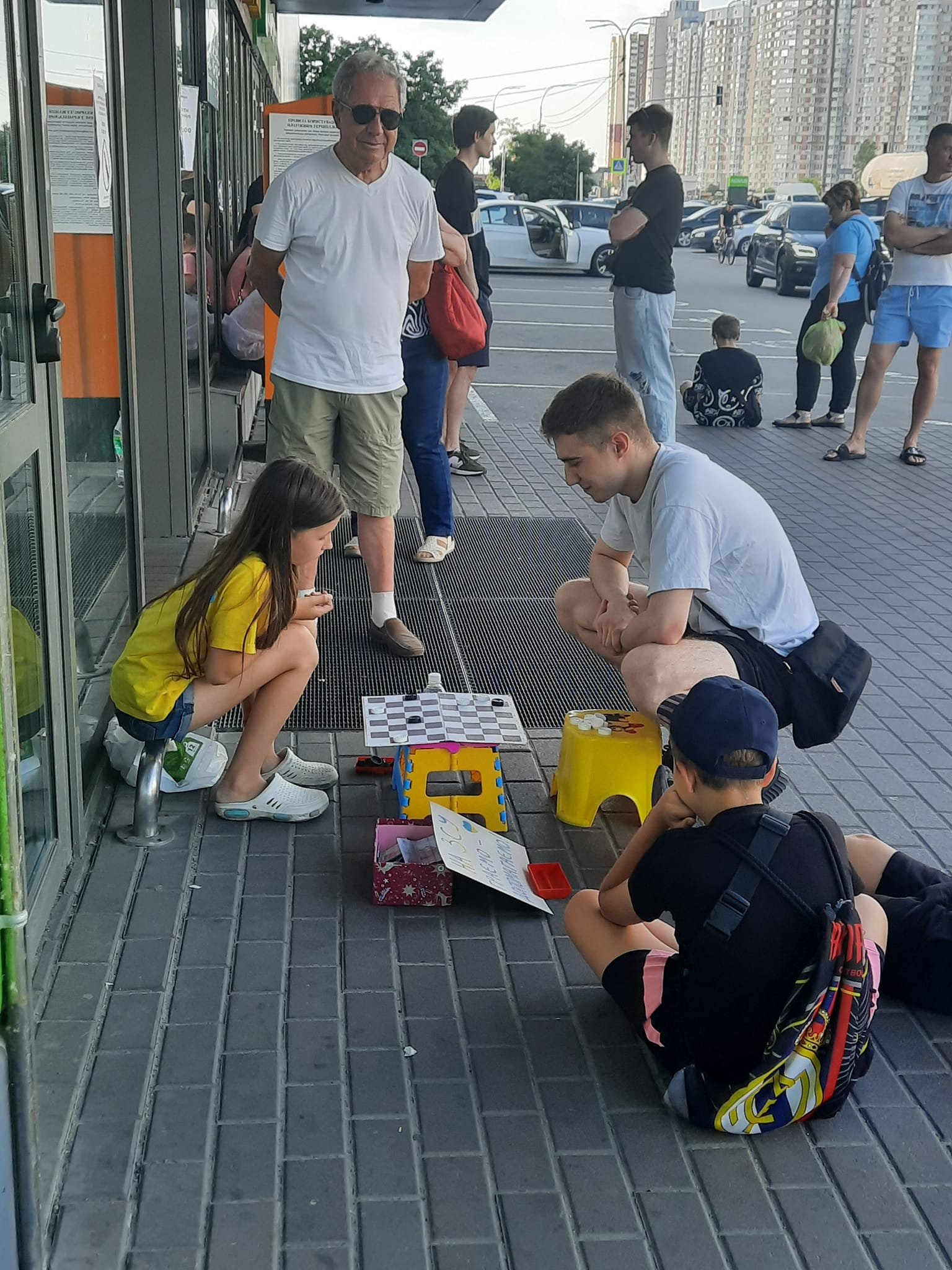 На Позняках девочка собирает деньги для ВСУ, играя с киевлянами в шашки.